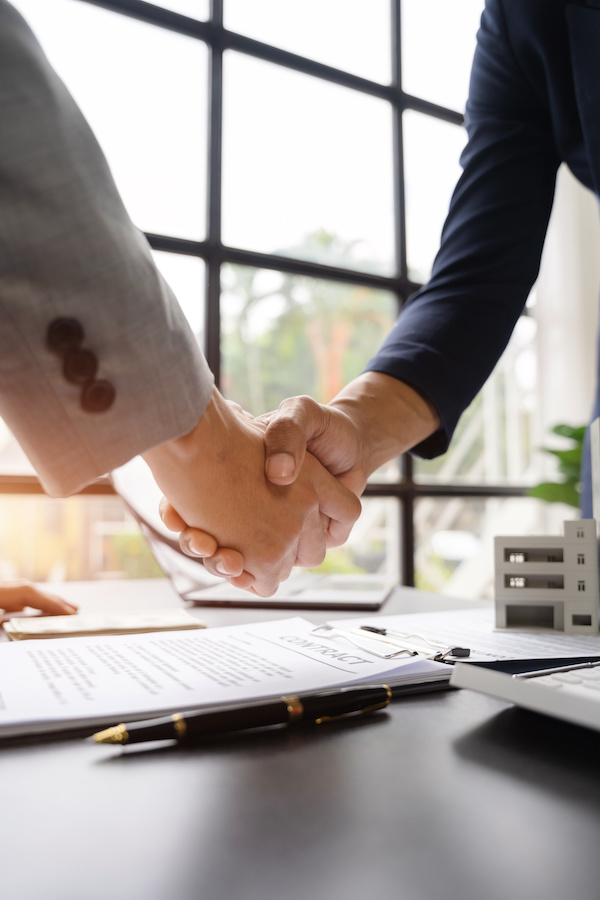 Close up shake hands, Considering buying a home, investing in real estate. Broker signs a sales agreement. agent, lease agreement, successful deal.